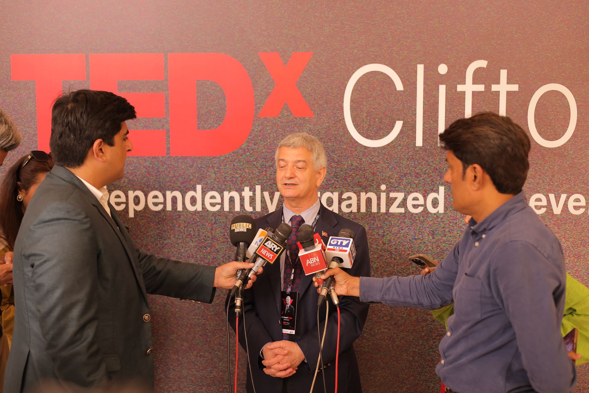 Featured speaker at TEDx Clifton being interviewed by multiple Pakistani national television channels including Public News, ARY News, ABN News, and GTV in front of the TEDx Clifton independently organized backdrop